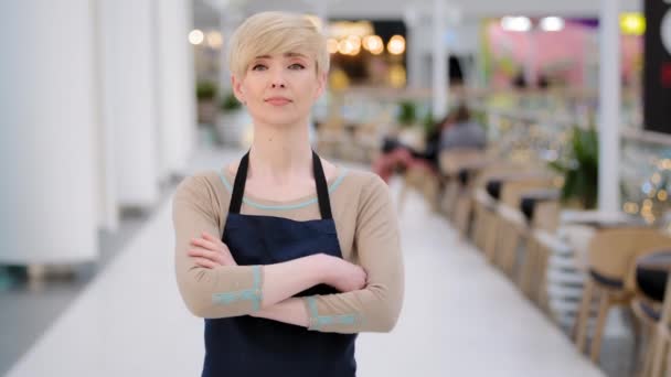 Mature adult middle aged 40s woman lady restaurant cafe worker looking at camera posing crossing arms female waitress saleswoman in apron standing at work space profession concept. Small business - Footage, Video