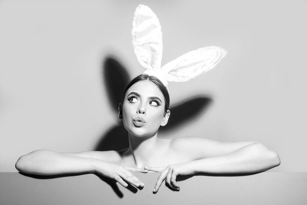 Easter young woman studio wearing bunny ears. curious isolated on pink. - Fotó, kép