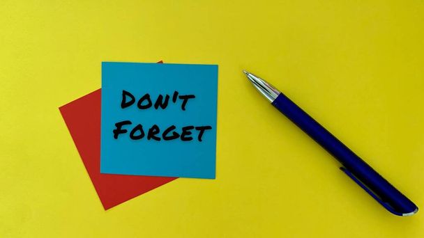 Do not forget - message on blue notepad. With pen and yellow background. Business concept. - Photo, Image