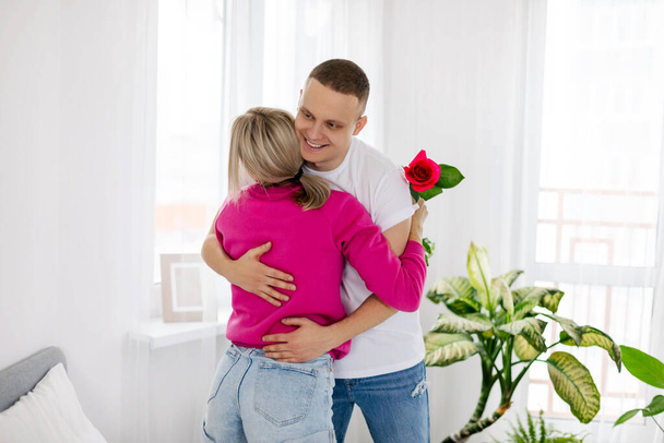 Una pareja joven se abrazan y se felicitan el día de San Valentín o el aniversario en la mañana del día festivo. - Foto, Imagen