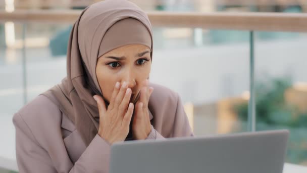 Triste estudiante musulmana chica en hijab mirando la pantalla del ordenador portátil de lectura de correo electrónico sorprendido por las malas noticias frustrada mujer de negocios se preocupa por los problemas financieros obtiene resultados del examen fallido abandono de la universidad trabajo perdido - Metraje, vídeo