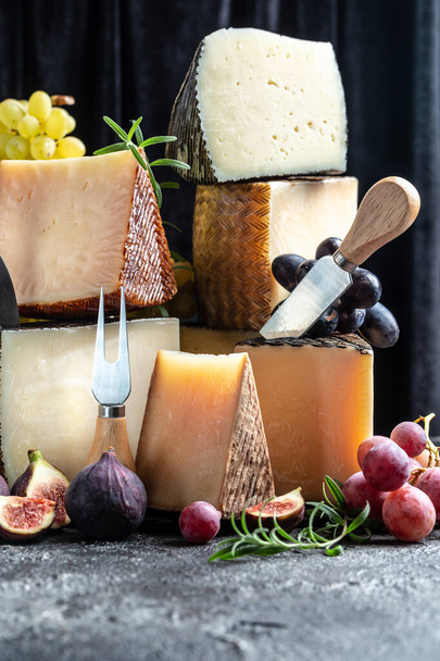 さまざまな種類のソフトチーズとハードチーズのチーズボード。スペインのマンチェゴチーズ国際的な乳製品料理。垂直画像. - 写真・画像
