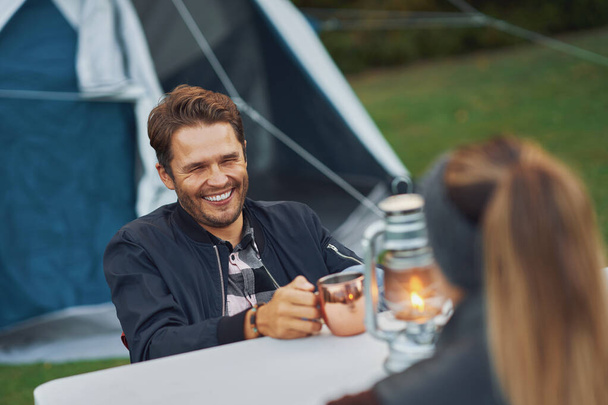 Jeune beau couple s'amusant sur le camping avec lampe au kérosène - Photo, image