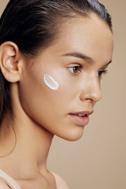 Brünette Gesichtsmaske Creme saubere Haut Gesichtspeeling beige Hintergrund - Foto, Bild