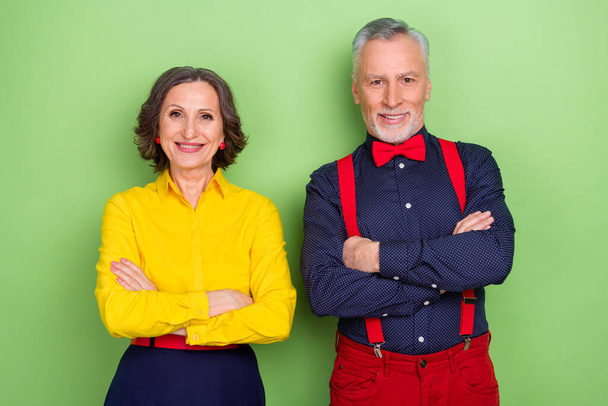 Portrait of two cheerful friendly aged persons crossed arms look camera isolated on green color background - Фото, зображення