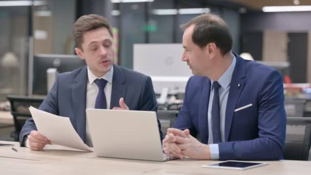 Gente de negocios discutiendo mientras trabaja en el ordenador portátil en la oficina  - Metraje, vídeo