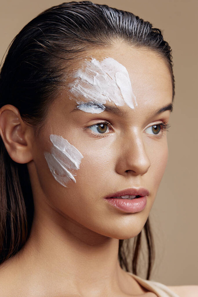 portrét žena s hydratační krém na tvářích v oblasti oka izolované pozadí - Fotografie, Obrázek