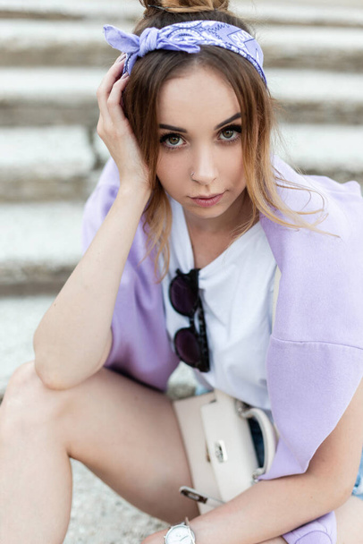 Portrait of beautiful young woman with bandana in white t-shirt and purple sweatshirt outdoors - Foto, Imagem