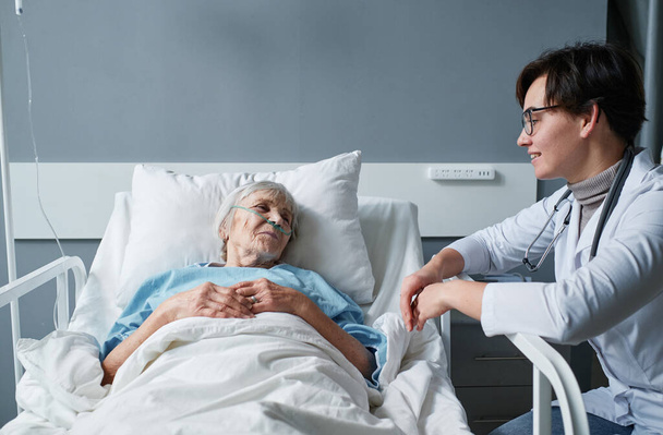 Seniorin spricht mit Krankenschwester auf der Station - Foto, Bild