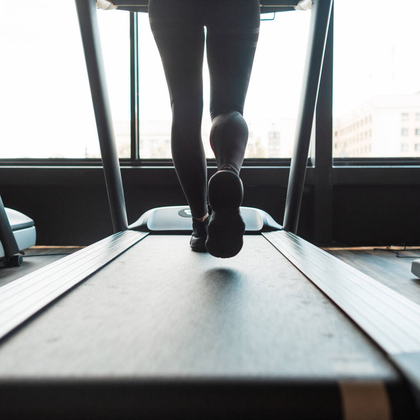 Girl running on a treadmill in gym, close-up - Zdjęcie, obraz