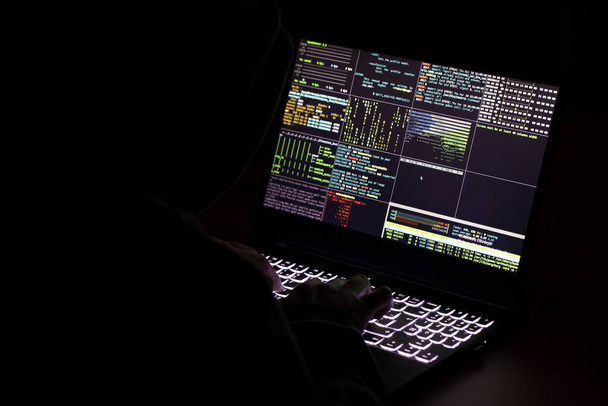 Програміст і хакер друкують код на клавіатурі ноутбука, щоб проникнути в таємничу організаційну систему. - Фото, зображення