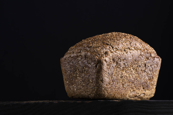 loaf of rye homemade bread in dark background. - Fotó, kép