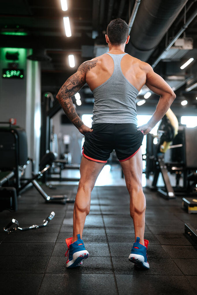Professional athlete working out at gym, doing legs training with weights on. Calves workout detail. Muscular man lifting weights at gym - Zdjęcie, obraz