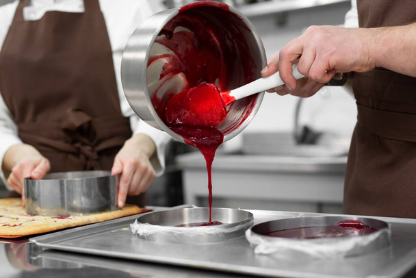 Woman and a man confectioners prepare berry filling for mousse cake - Foto, Bild