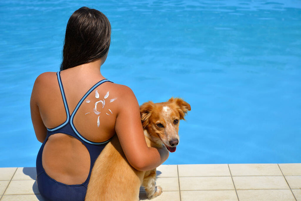 Skutečný rozkošný dívka relaxační v bazénu se svým psem, letní dovolená koncept - Fotografie, Obrázek