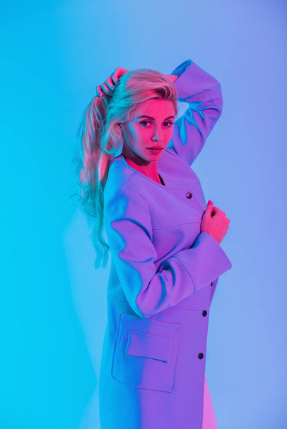 Stylish blonde beauty model woman with fashion elegant colored blazer with neon pink light blonde in the studio - Zdjęcie, obraz