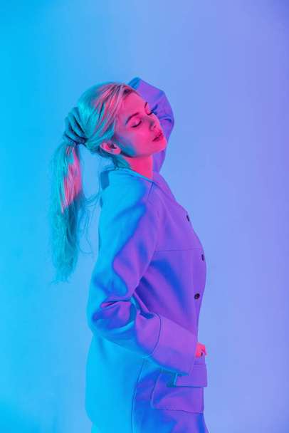 Beautiful pastel colors portrait of beautiful stylish woman model with fashionable blue blazer rest with neon pink lights - Zdjęcie, obraz