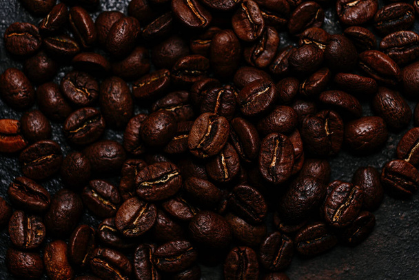 Pečená kávová zrna zblízka na tmavém pozadí. Kolumbijská káva - Fotografie, Obrázek
