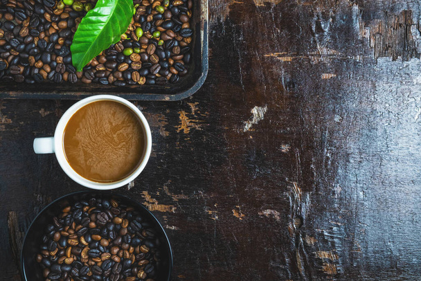 šálek kávy a kávových zrn na dřevěný stůl - Fotografie, Obrázek