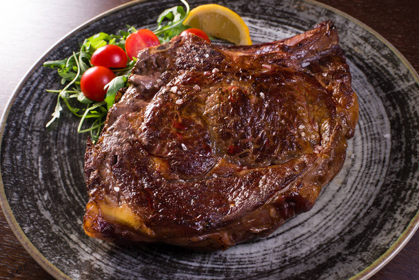 Detail vom Steak auf Teller über Holztisch - Foto, Bild