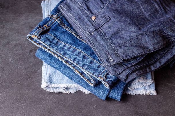blue and light blue jeans lie on a brown background - Photo, Image