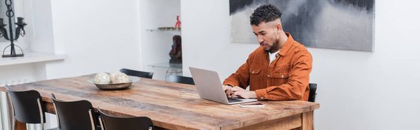 african american freelancer typing on laptop while working from home, banner - Фото, изображение