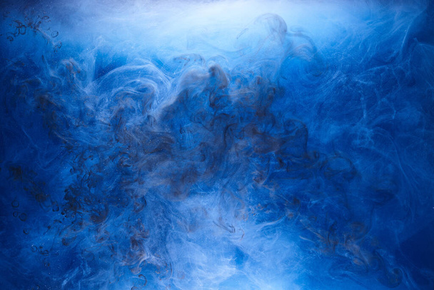 Blue smoke on black ink background, colorful fog, abstract swirling ocean sea, acrylic paint pigment underwater - Фото, изображение