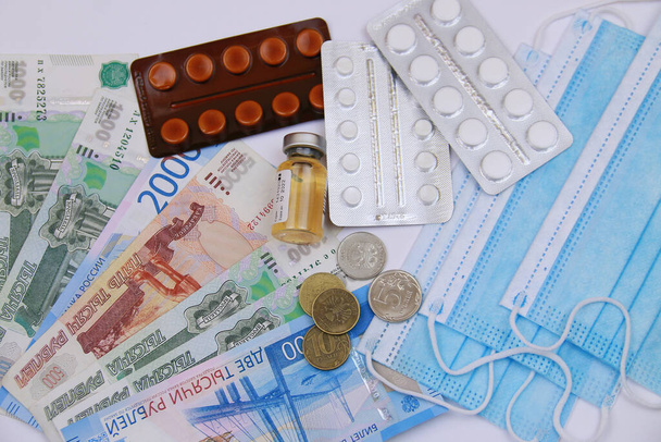 Coronavirus, an epidemic. Protective medical mask, syringe, antibiotics, pills and Russian money - Fotó, kép