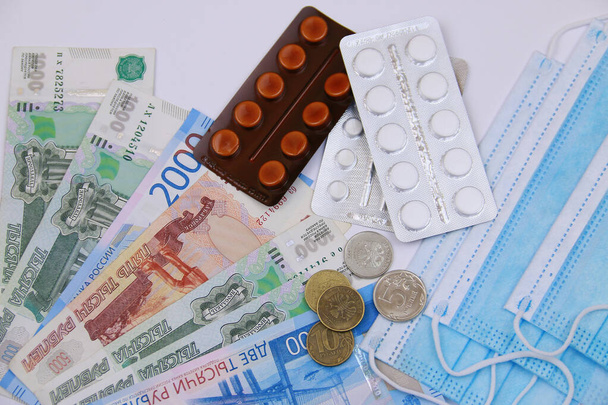 Medios de protección contra el virus. Máscara médica, pastillas contra el fondo del dinero ruso - Foto, imagen