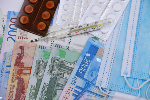 The composition of protective agents against coronavirus. Medical mask, thermometer, pills, Russian money. - Foto, imagen