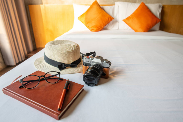 De set van reisbenodigdheden arrangement op het bed in gezellig hotel, voor te bereiden voorwerpen voor reizen. Conceptuele reis- en vakantie-achtergrond. - Foto, afbeelding