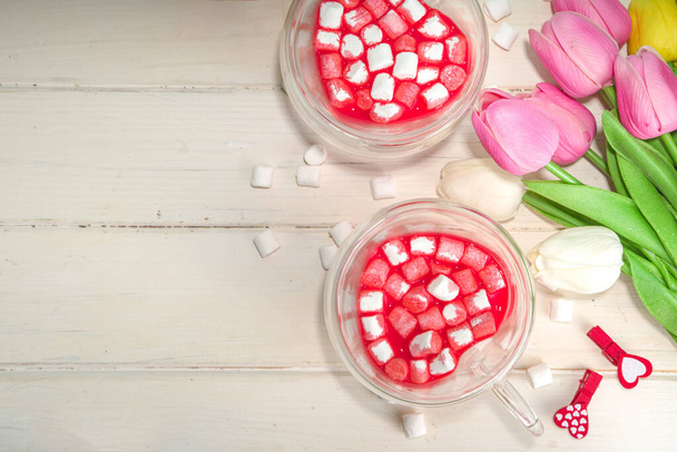 Šálek ve tvaru srdce s červenou sametovou horkou čokoládou, s malými marshmallows, dárkovou krabičkou a květinami na Valentýna - Fotografie, Obrázek