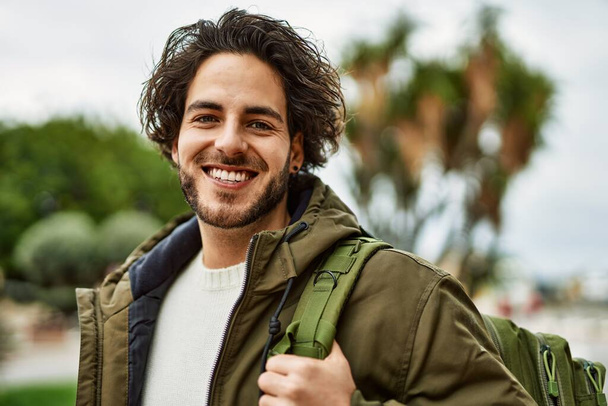 Красивий іспаномовний чоловік посміхається в парку
 - Фото, зображення