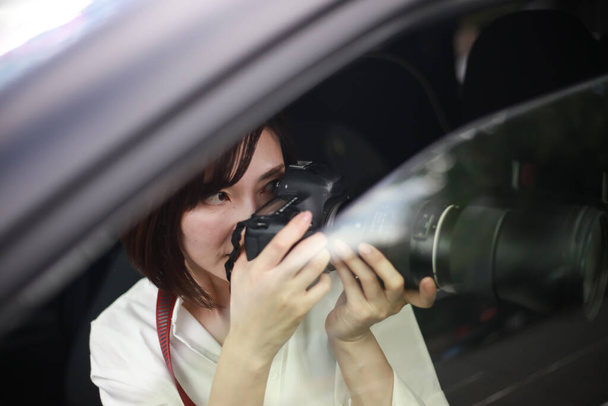  όμορφη ασιατική νεαρή γυναίκα με κάμερα στο αυτοκίνητο, παπαράτσι - Φωτογραφία, εικόνα
