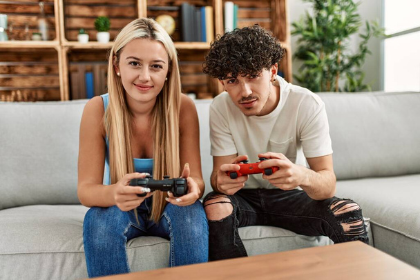 Молода пара посміхається щаслива гра в відеогру вдома
. - Фото, зображення
