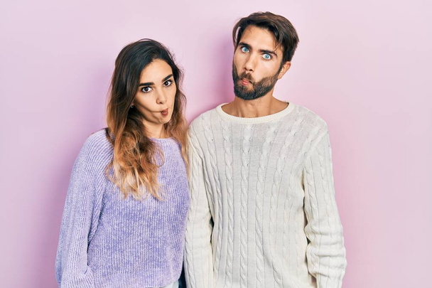 Young hispanic couple wearing casual clothes making fish face with lips, crazy and comical gesture. funny expression.  - Фото, изображение