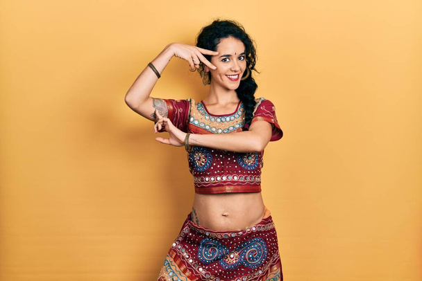 Young indian woman wearing traditional belly dancer costume. Dancing exotic oriental dance with body and hands - Foto, afbeelding