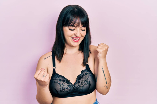 Young hispanic woman wearing lingerie celebrating surprised and amazed for success with arms raised and eyes closed  - Photo, Image