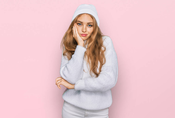 Young caucasian girl wearing wool sweater and winter cap thinking looking tired and bored with depression problems with crossed arms.  - Photo, Image