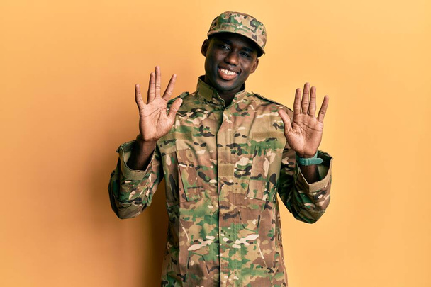 Young african american man wearing army uniform showing and pointing up with fingers number ten while smiling confident and happy.  - Foto, Imagem