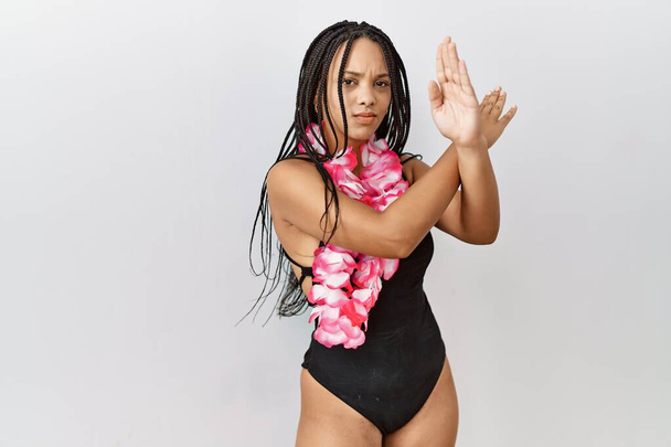 水着を着た若いアフリカ系アメリカ人女性とハワイのレイ拒否表現交差腕負の記号を行う,怒っている顔  - 写真・画像