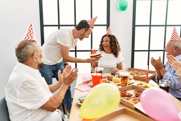 Група друзів середнього віку посміхається щасливо відзначати день народження вдома
. - Фото, зображення
