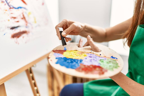 Латиноамериканка средних лет рисует в художественной студии - Фото, изображение