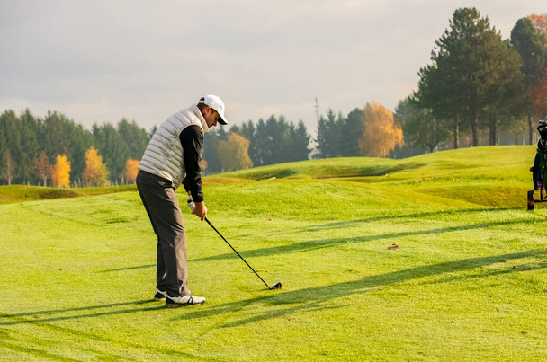 Golfer προσπαθεί να κάνει την τέλεια βολή με ένα μπαστούνι του γκολφ - Φωτογραφία, εικόνα