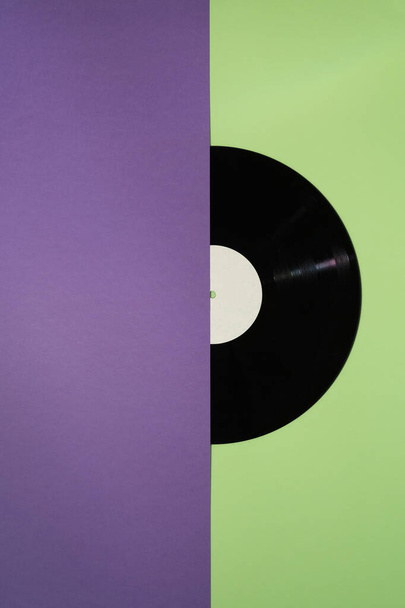 Vinyl record on a purple and green background - Фото, зображення