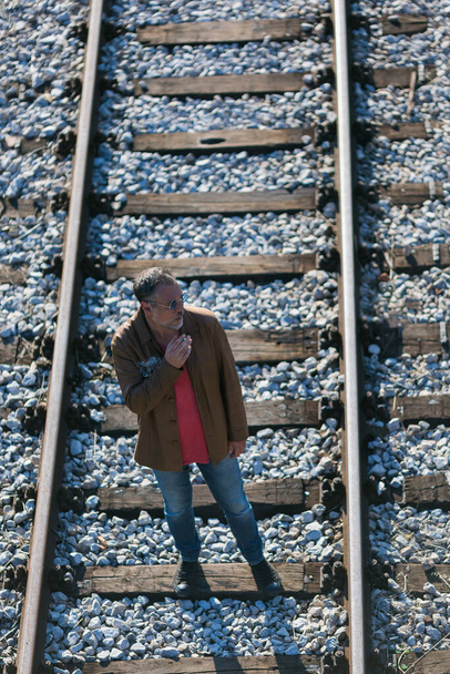 lonely man standing on railroad tracks - Foto, imagen