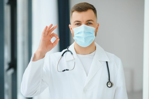 Portrait of male doctor wearing surgical mask is ready to help patients with coronavirus or covid virus. - Zdjęcie, obraz