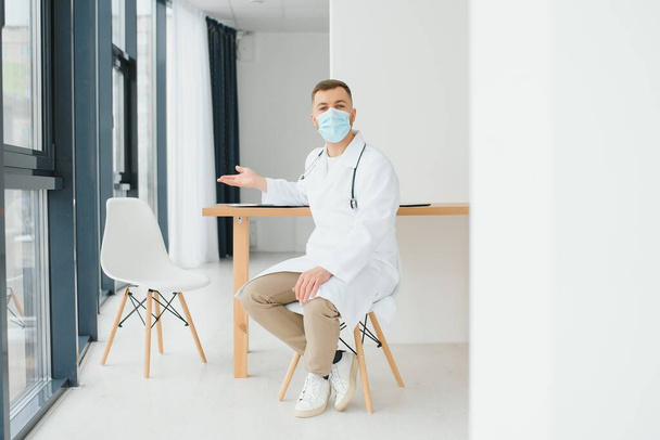Male doctor near reception desk in clinic - Photo, image