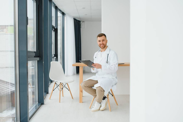 Male doctor near reception desk in clinic - Zdjęcie, obraz