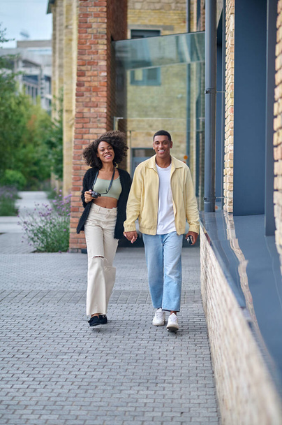 Man and woman holding hand walking on street - Photo, image